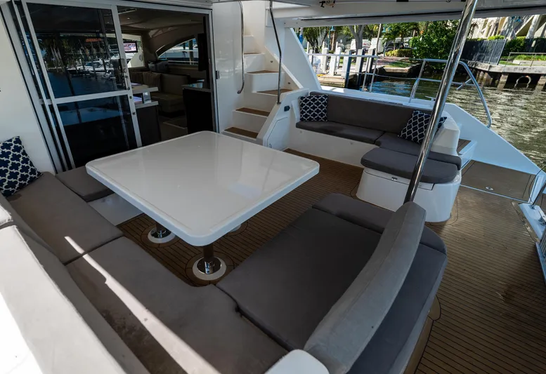  Yacht Photos Pics Spacious outdoor seating area on 2014 Leopard 51 Powercat yacht with table and cushions.