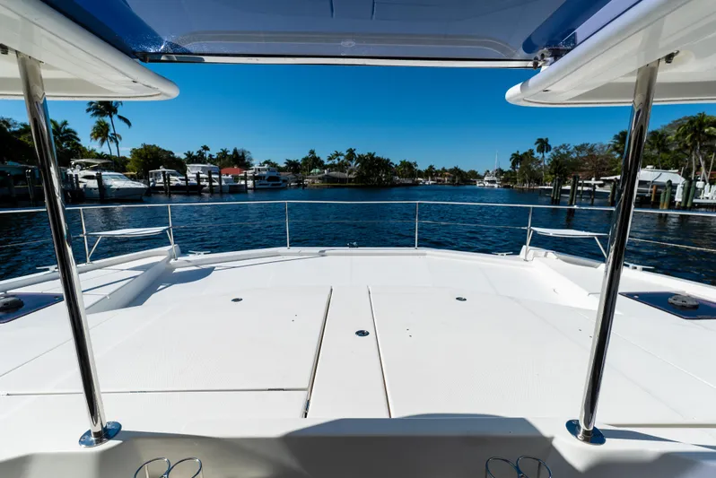  Yacht Photos Pics 2014 Leopard 51 Powercat deck overlooking serene waterfront with palm trees and clear blue sky.