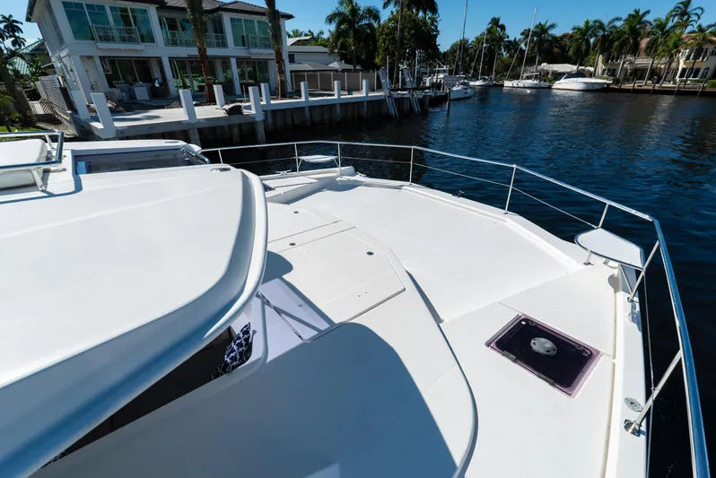  Yacht Photos Pics 2014 Leopard 51 Powercat yacht docked by waterfront homes and palm trees.