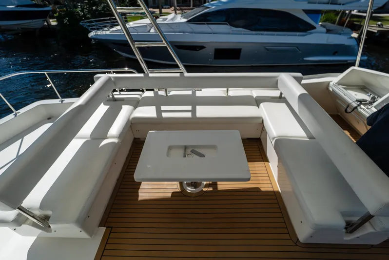  Yacht Photos Pics 2014 Leopard 51 Powercat deck with white seating and table, docked near another boat.