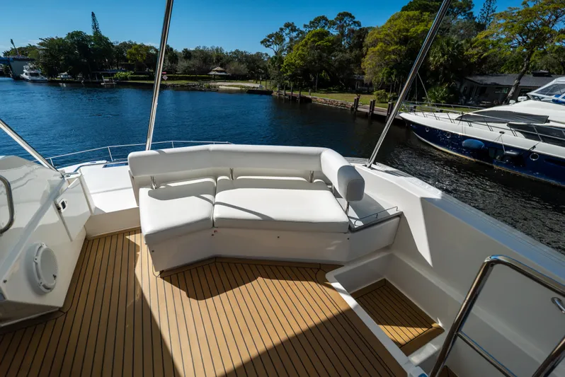  Yacht Photos Pics 2014 Leopard 51 Powercat deck with white seating, overlooking serene water and lush greenery.