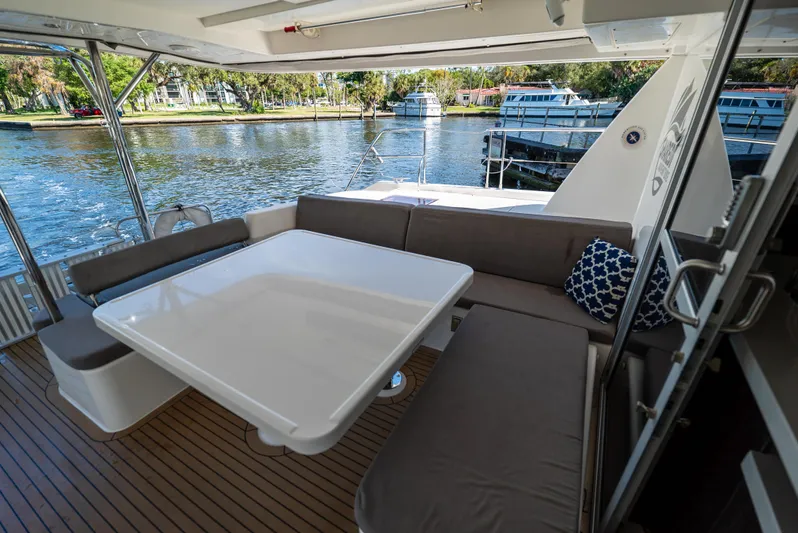  Yacht Photos Pics Leopard 51 Powercat 2014 yacht interior with seating and table, overlooking serene waterfront.