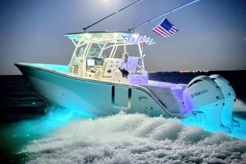  Yacht Photos Pics 2017 Sea Fox 328 Commander boat illuminated at night, cruising with American flag.