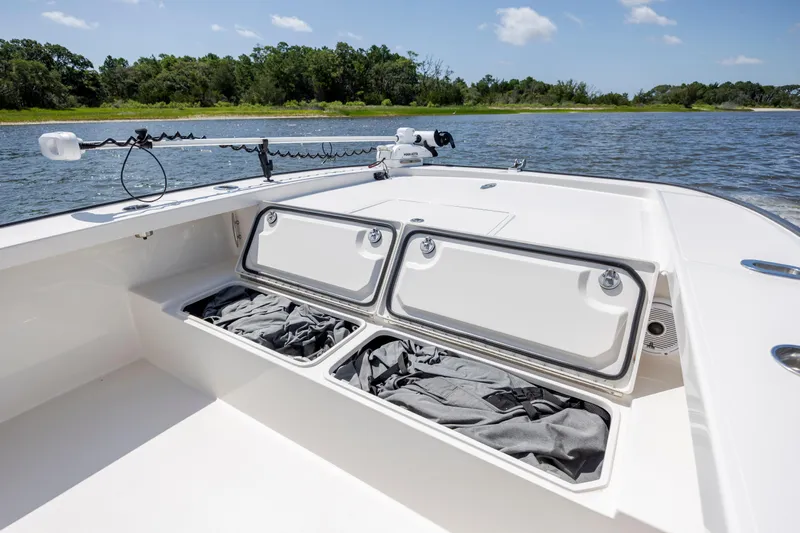  Yacht Photos Pics 2023 Calcutta 263 boat with open storage compartments on a sunny day by the water.