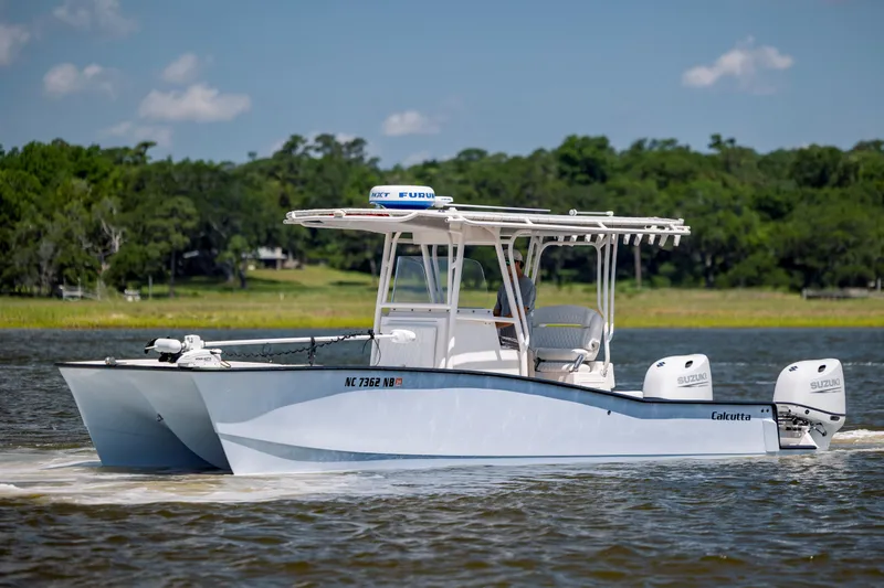  Yacht Photos Pics 2023 Calcutta 263 boat cruising on a scenic waterway with lush greenery.