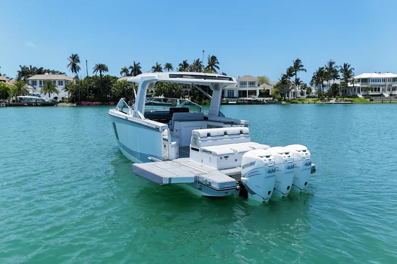  Yacht Photos Pics 2023 Aviara AV40 OB boat with triple outboard engines on a serene waterfront.