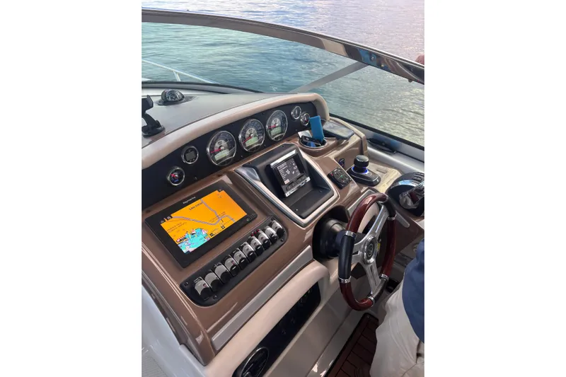  Yacht Photos Pics 2018 Crownline 350 SY helm with navigation screens and controls on a calm water backdrop.