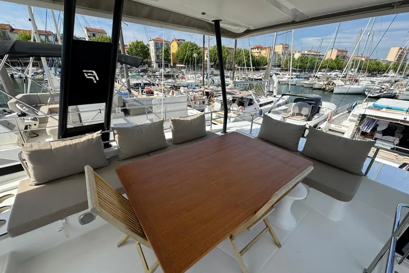 November Xiii Yacht Photos Pics Fountaine Pajot MY 44 yacht, 2019 model, featuring a spacious outdoor seating area in a marina.