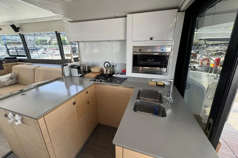 November Xiii Yacht Photos Pics Modern kitchen interior on 2019 Fountaine Pajot MY 44 yacht, featuring sleek countertops and appliances.