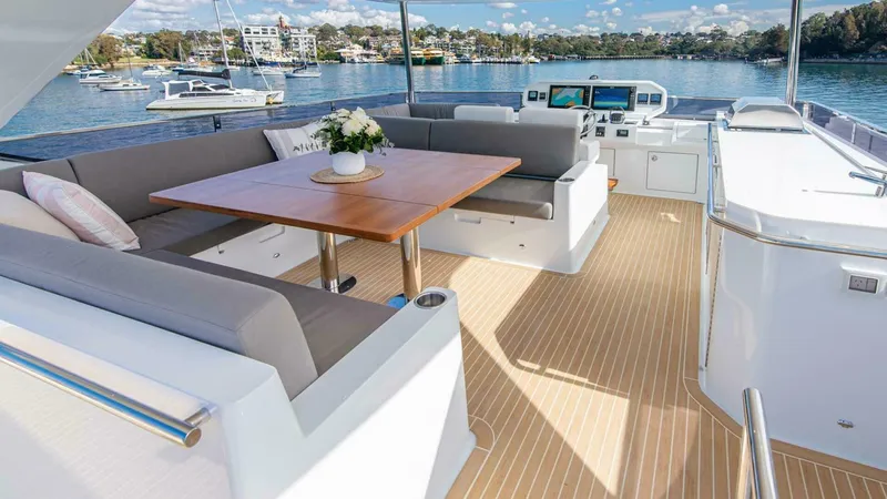 53f Iliad 2026 Yacht Photos Pics Luxurious 2026 ILIAD 53F yacht deck with seating, table, and scenic waterfront view.
