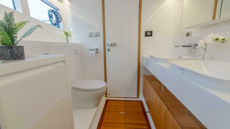 53f Iliad 2026 Yacht Photos Pics Modern yacht bathroom with dual sinks, wooden accents, and potted plants, ILIAD 53F, 2026 model.