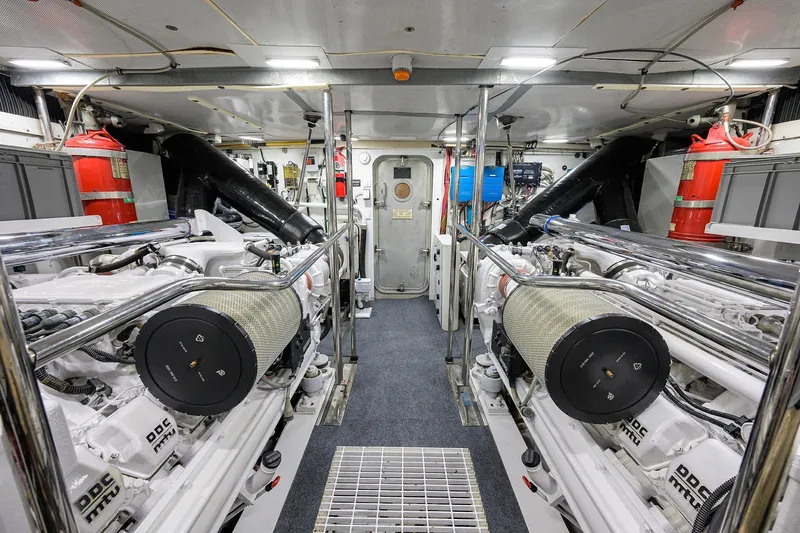 Jule Yacht Photos Pics Engine room of a 2005 Pacific Mariner 85 yacht, featuring dual engines and fire extinguishers.