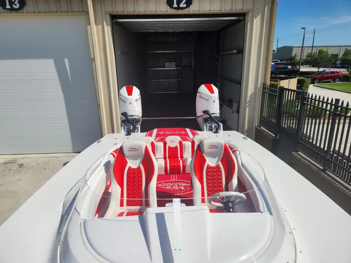  Yacht Photos Pics 2022 HellCat 32 Wide Body boat with red and white interior, dual engines, docked in a garage.
