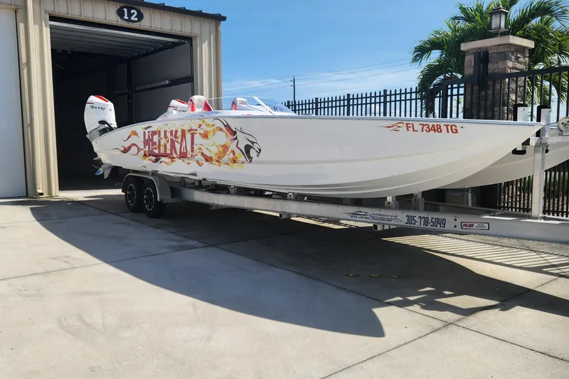  Yacht Photos Pics 2022 HellCat 32 Wide Body boat on trailer, parked outside a garage.