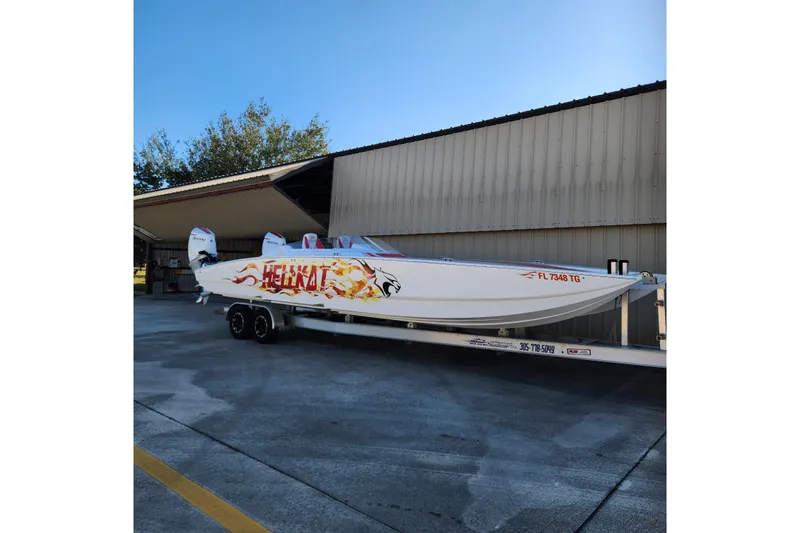  Yacht Photos Pics 2022 HellCat 32 Wide Body boat with flame graphics on a trailer.