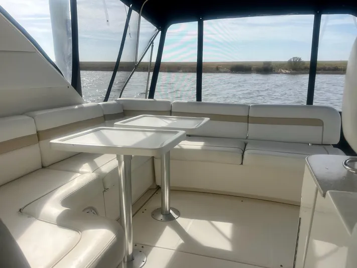 Be A Blessing II Yacht Photos Pics 2009 Sea Ray 4300 Sundancer interior with white seating and tables, overlooking water.