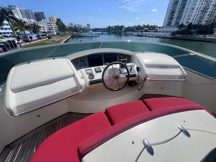  Yacht Photos Pics 2004 Azimut Leonardo 98 yacht helm with red seating, overlooking a scenic waterfront.