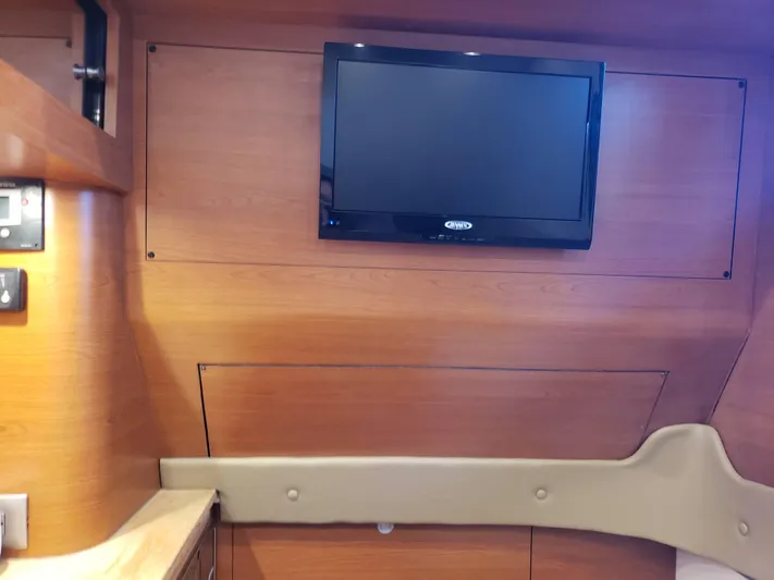 Yacht Photos Pics Interior of 2016 Mystic Powerboats M4200 with wall-mounted TV and wooden paneling.