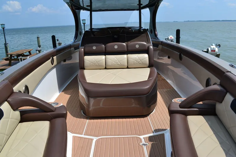  Yacht Photos Pics 2016 Mystic Powerboats M4200 interior with luxurious seating and wood finish, docked by the sea.