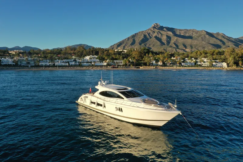 Carbon Copy V Yacht Photos Pics Luxury 2009 Lazzara LSX 75 yacht on serene water with mountain backdrop.