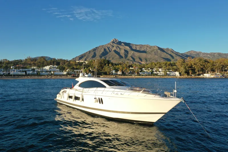 Carbon Copy V Yacht Photos Pics Luxury 2009 Lazzara LSX 75 yacht on serene water with mountain backdrop.