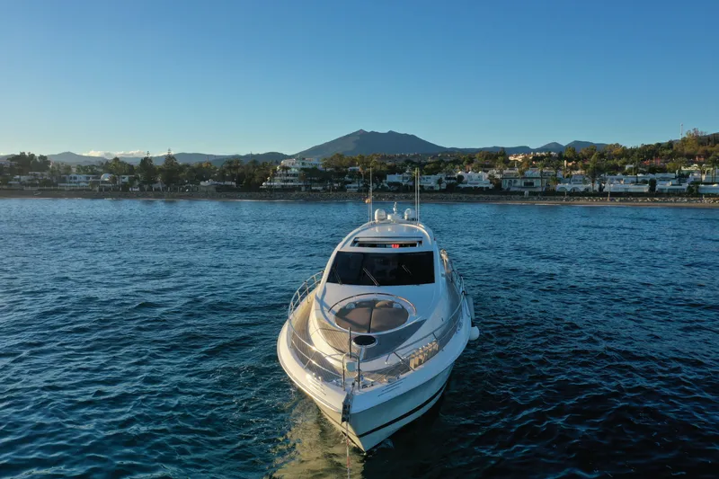 Carbon Copy V Yacht Photos Pics 2009 Lazzara LSX 75 yacht on serene water with scenic coastal backdrop.