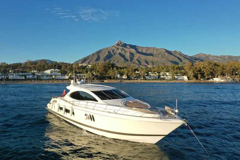 Carbon Copy V Yacht Photos Pics Luxury 2009 Lazzara LSX 75 yacht cruising near scenic coastal landscape.