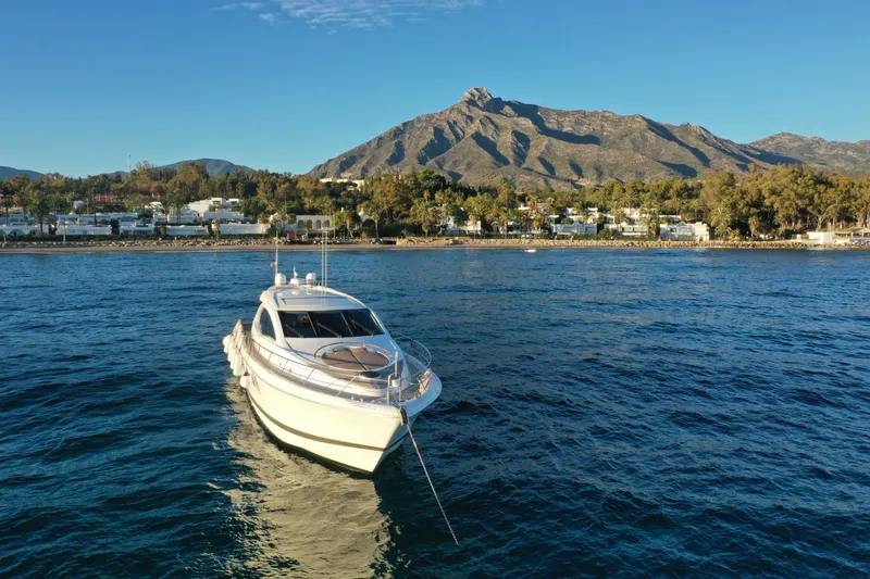 Carbon Copy V Yacht Photos Pics 2009 Lazzara LSX 75 yacht anchored near scenic coastal landscape with mountains.