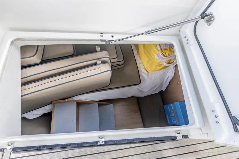 Blue Sky Yacht Photos Pics Storage compartment in a 2012 Beneteau Sense 50 yacht, featuring cushions and a yellow life jacket.
