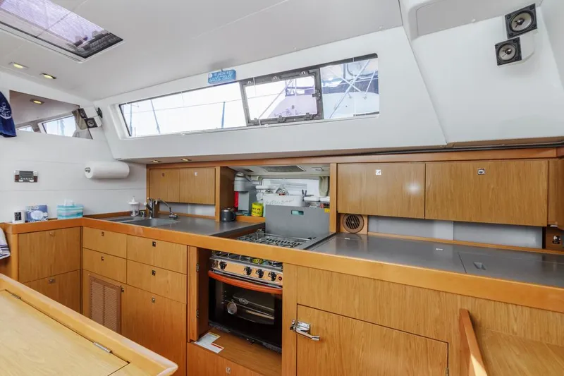 Blue Sky Yacht Photos Pics Interior of 2012 Beneteau Sense 50 yacht kitchen with wooden cabinetry and modern appliances.