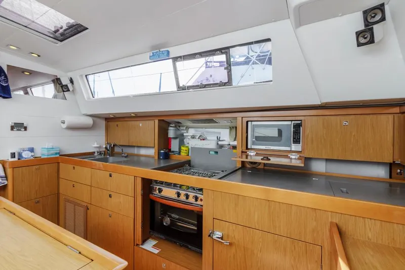 Blue Sky Yacht Photos Pics Interior of 2012 Beneteau Sense 50 yacht kitchen with modern appliances and wooden cabinetry.