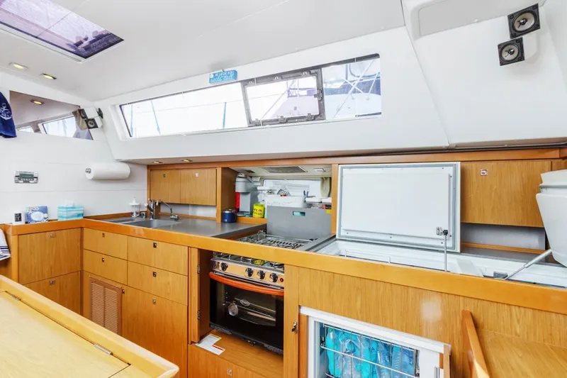 Blue Sky Yacht Photos Pics Interior of 2012 Beneteau Sense 50 yacht kitchen with wooden cabinetry and modern appliances.