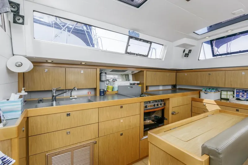 Blue Sky Yacht Photos Pics Modern kitchen interior of 2012 Beneteau Sense 50 yacht with wooden cabinetry and appliances.