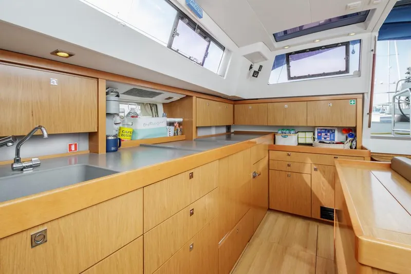 Blue Sky Yacht Photos Pics Spacious kitchen area in a 2012 Beneteau Sense 50 yacht, featuring modern wood cabinetry.