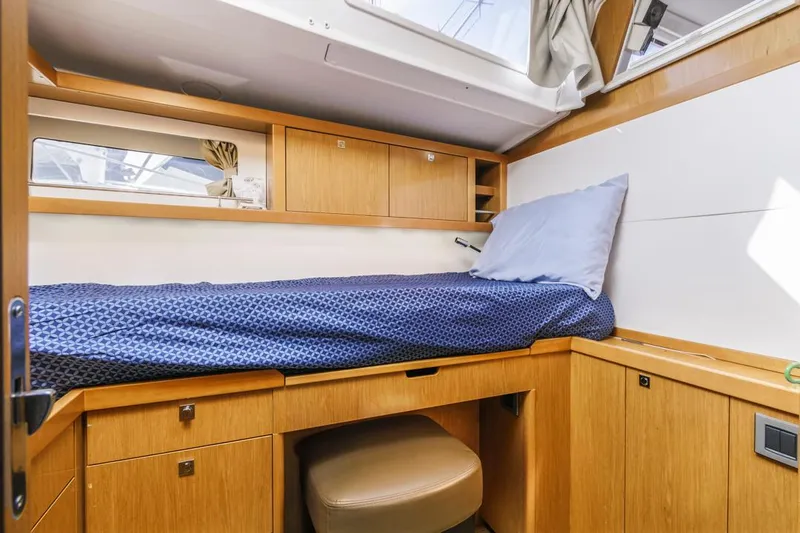 Blue Sky Yacht Photos Pics Cozy cabin interior of 2012 Beneteau Sense 50 yacht with wooden furnishings and single bed.