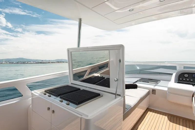  Yacht Photos Pics Luxurious 2015 Maiora 24S yacht deck with grill and seating, overlooking serene ocean view.