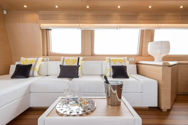  Yacht Photos Pics Luxurious Maiora 24S yacht interior with white sofa, decorative pillows, and elegant table setting.