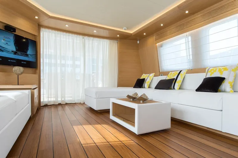  Yacht Photos Pics Luxurious Maiora 24S 2015 yacht interior with elegant white seating, wooden flooring, and modern decor.