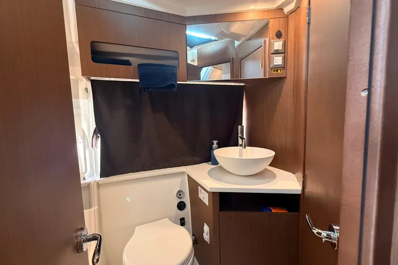  Yacht Photos Pics 2024 Beneteau Antares 11 bathroom with modern sink and wooden cabinetry.