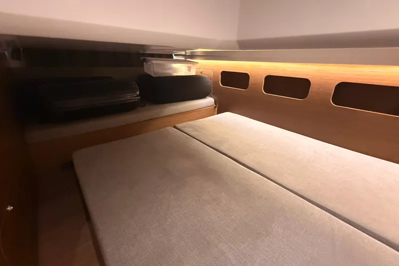  Yacht Photos Pics 2024 Beneteau Antares 11 cabin interior with cozy bedding and storage space.