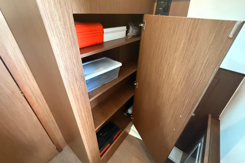  Yacht Photos Pics Open wooden cabinet with shelves on 2024 Beneteau Antares 11 boat.