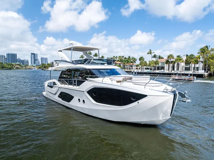 Lobster Tails Yacht Photos Pics 2023 Absolute 52 FLY yacht cruising on a sunny day with cityscape background.