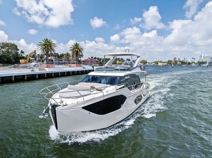 Lobster Tails Yacht Photos Pics 2023 Absolute 52 FLY yacht cruising on a sunny day with palm trees in the background.