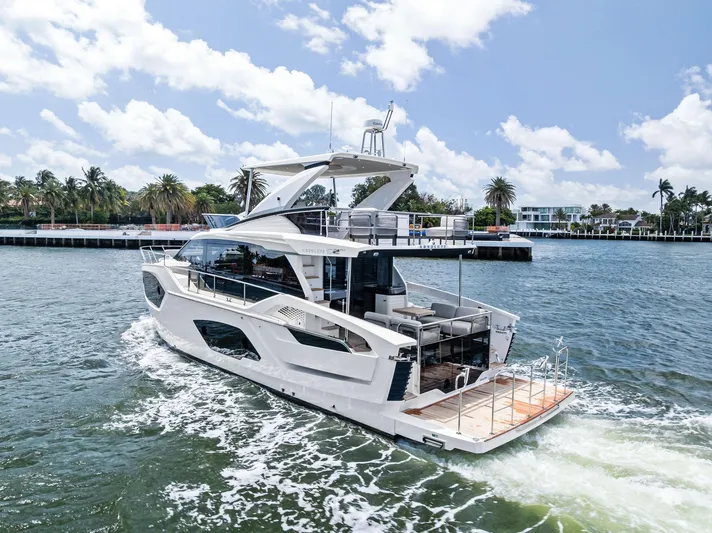 Lobster Tails Yacht Photos Pics 2023 Absolute 52 FLY yacht cruising on a sunny day, surrounded by palm trees and waterfront homes.