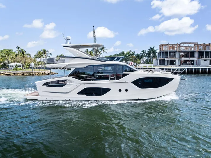 Lobster Tails Yacht Photos Pics 2023 Absolute 52 FLY yacht cruising on a sunny day near waterfront homes.