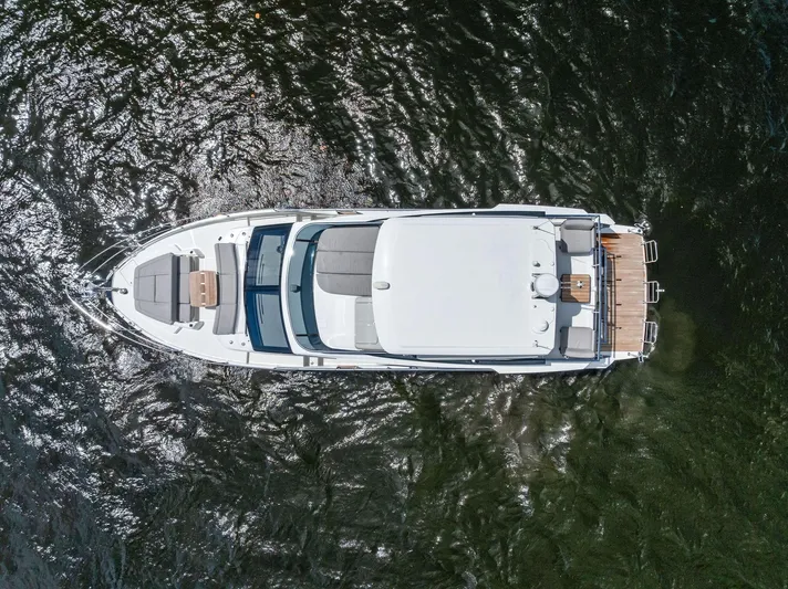 Lobster Tails Yacht Photos Pics Aerial view of 2023 Absolute 52 FLY yacht on water, showcasing sleek design and spacious deck.