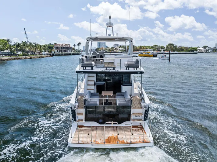 Lobster Tails Yacht Photos Pics 2023 Absolute 52 FLY yacht cruising on a sunny day, showcasing luxurious design and spacious deck.