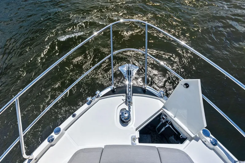 Lobster Tails Yacht Photos Pics Bow view of 2023 Absolute 52 FLY yacht on water, showcasing sleek design and railing.