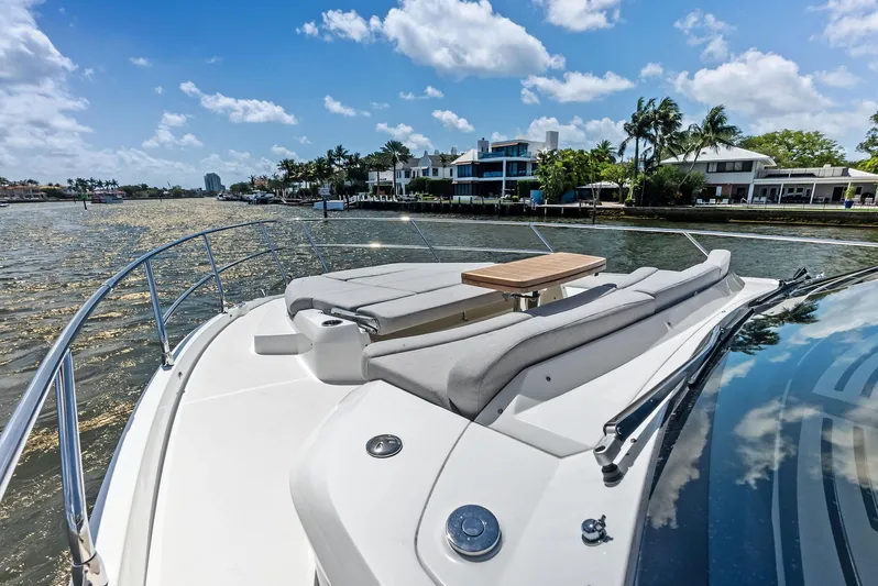 Lobster Tails Yacht Photos Pics 2023 Absolute 52 FLY yacht cruising on a sunny day with waterfront homes in the background.