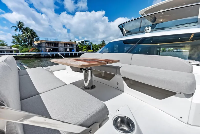 Lobster Tails Yacht Photos Pics Luxurious 2023 Absolute 52 FLY yacht with elegant outdoor seating and table.